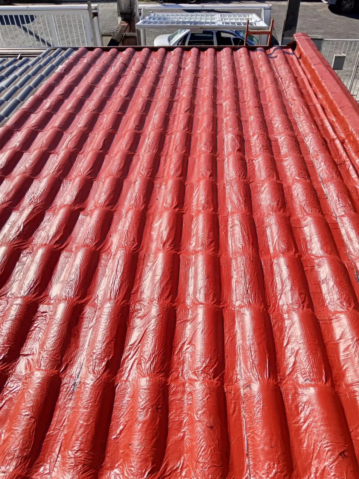 Telhado corrugado com acabamento vermelho após revitalização